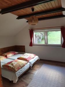 1 dormitorio con 2 camas y ventana en Ubytovanie Liptov, en Liptovský Michal