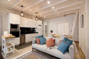 a living room with a couch and a kitchen at Casa na Travessa in Faro