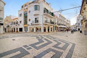 a cobblestone street in a city with buildings at Casa na Travessa in Faro