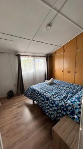 1 dormitorio con 1 cama con manta azul en Dúplex Los Mañios, en Coyhaique