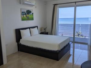 Un dormitorio con una cama con vista al mar. en Inn The Town, en Port Antonio 58 fotos más