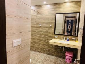 uma casa de banho com um lavatório e um espelho em Harveys Guest House em Islamabad