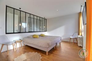 a bedroom with a bed with two yellow pillows on it at Chambre à la ferme TORCE in Torcé