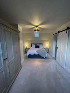 a bedroom with a bed and two closets in it at Newly built house with elegant touches... in Todenham