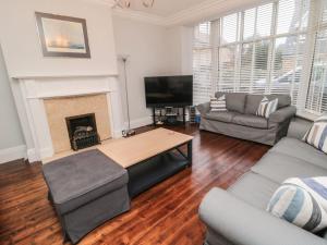 a living room with a couch and a fireplace at Glenander in Bamburgh