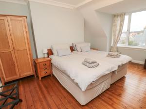 a bedroom with a bed and a wooden floor at Glenander in Bamburgh