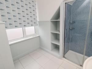 a bathroom with a shower and a toilet and a window at Glenander in Bamburgh +42 photos