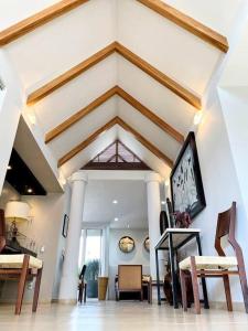 a living room with a vaulted ceiling with a table and chairs at Piece of Paradise in the city in Guadalajara