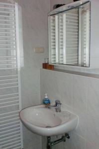 a white sink in a bathroom with a mirror at FeWo ab 3 Übernachtungen in Dresden