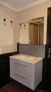 La salle de bains est pourvue d'un lavabo blanc et d'un miroir. dans l'établissement Gîte Lachevalle, à Saint-Jean-dʼAngély