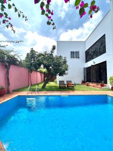 a swimming pool in front of a house at The Dzorwulu Castle - A Villa with private rooms in Accra