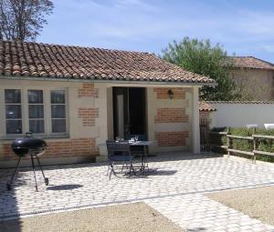 un patio con parrilla frente a una casa en Gîte Lachevalle, en Saint-Jean-dʼAngély