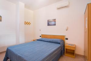 een slaapkamer met een bed met een blauwe sprei bij One Love apartments in Lupetto
