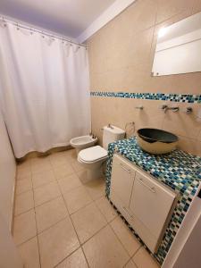 un baño con inodoro y lavabo en Casita Catalejo Travel, en Puerto Madryn