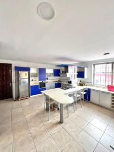 a large kitchen with blue cabinets and a table at The Dzorwulu Castle - A Villa with private rooms in Accra