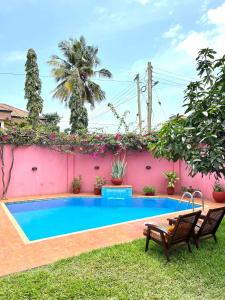 een zwembad in de achtertuin van een huis bij The Dzorwulu Castle - A Villa with private rooms in Accra