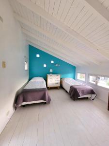 Dos camas en una habitación con paredes azules. en Casita Catalejo Travel, en Puerto Madryn