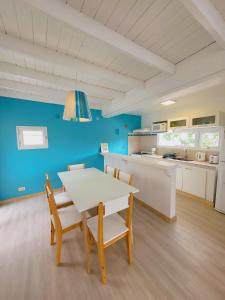 Una cocina y un comedor con mesa y sillas. en Casita Catalejo Travel, en Puerto Madryn