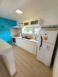 Una cocina con un refrigerador blanco en una habitación. en Casita Catalejo Travel, en Puerto Madryn 4 fotos más