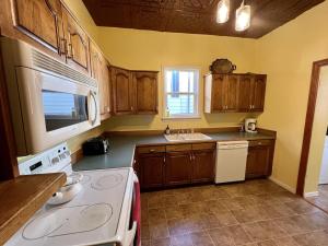 cocina con armarios de madera y horno de fogón blanco en NEW! Beautiful Queen Ann in Historic Butte, Montana, en Butte