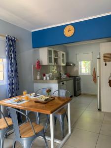 una cocina con mesa y sillas y un reloj en el techo en Lilu Apartments Curaçao, en Willemstad