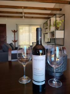 una botella de vino y dos copas de vino en una mesa en San Bernardo Housing en Salta