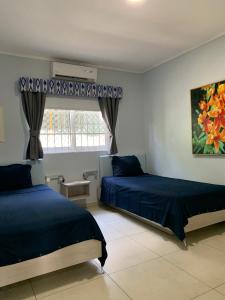 1 dormitorio con 2 camas y ventana en Lilu Apartments Curaçao, en Willemstad