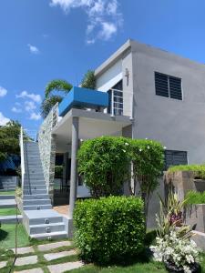 una casa blanca con escaleras y arbustos delante en Lilu Apartments Curaçao, en Willemstad
