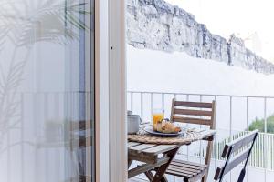 einen Tisch mit einem Teller Essen auf dem Balkon in der Unterkunft Wonderful Duplex W Private Patio & AC by LovelyStay in Porto