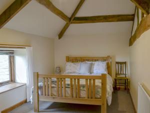 um quarto com uma cama de madeira e uma janela em The Cider House em Bredenbury