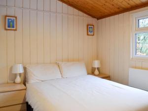 a bedroom with a white bed and two lamps at Cedar Lodge in Ellington