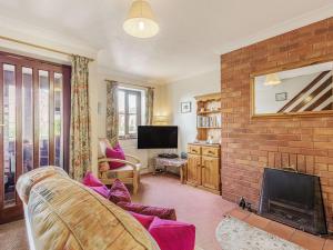 a living room with a couch and a fireplace at Nightingale Cottage in Castle Acre