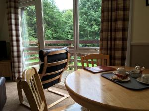 Glenurguhart的住宿－Thistle Lodge - Uk7051，一间带桌椅和窗户的用餐室