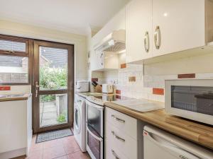 a kitchen with white appliances and a window in it at Nightingale Cottage in Castle Acre