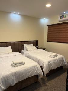 2 łóżka w pokoju hotelowym z ręcznikami w obiekcie Sultan Home w mieście Wadi Musa