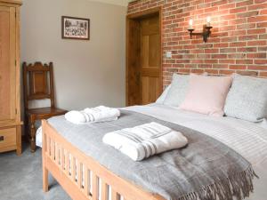a bedroom with a large bed with towels on it at Well Cottage in Itchingfield