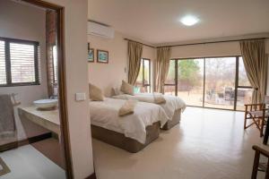 a bedroom with two beds and a bathroom with a sink at The Jasper House 73 in Mabula