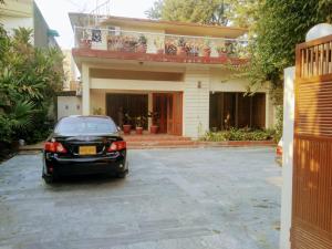 a black car parked in front of a house at Pyramid International Guest House in Islamabad