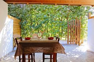 a table and chairs in a patio with a large tree at Villaggio Camping Sentinella in Torre dell'Orso