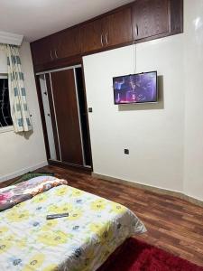 - une chambre avec 2 lits et une télévision murale dans l'établissement Résidence Faouazi, à Casablanca