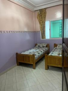 - une chambre avec 2 lits et un miroir dans l'établissement Résidence Faouazi, à Casablanca