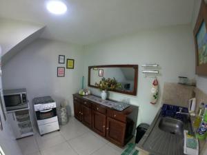 eine Küche mit einem Waschbecken und einem Spiegel an der Wand in der Unterkunft Casa para Família com Piscina in Luis Correia