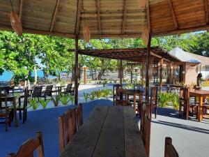 an outdoor restaurant with a wooden table and chairs at Resort Ondas Praia apart in Porto Seguro