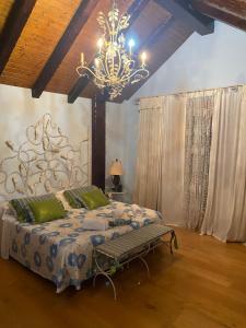 1 dormitorio con 1 cama grande y lámpara de araña en Casa Santiago, en Argoños