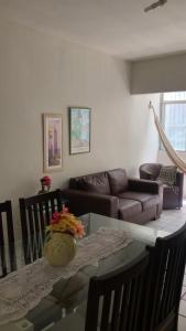 uma sala de estar com uma mesa de vidro e um sofá em Apt Candeias para 6 pessoas no Recife