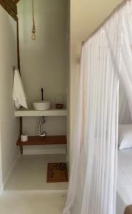 a bathroom with a white shower curtain and a sink at Chalés da Floresta in Porto Seguro