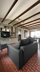 sala de estar con sofá negro y mesa en San Bernardo Housing en Salta