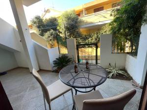 a patio with a table and chairs and a building at Residenza ICHNUSA in Villasimius