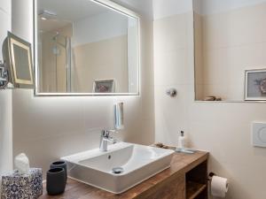 ein weißes Badezimmer mit einem Waschbecken und einem Spiegel in der Unterkunft Ferienwohnung Krabbe in Wangerooge