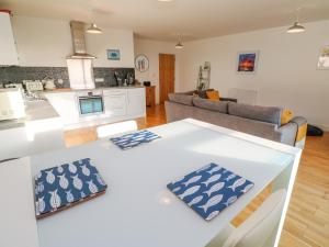a kitchen and living room with a white counter top at 11 Seaquest in Newquay